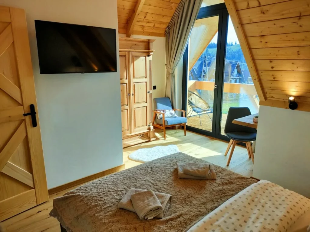 Sypialnia z podwójnym łóżkiem i wyjściem na balkon