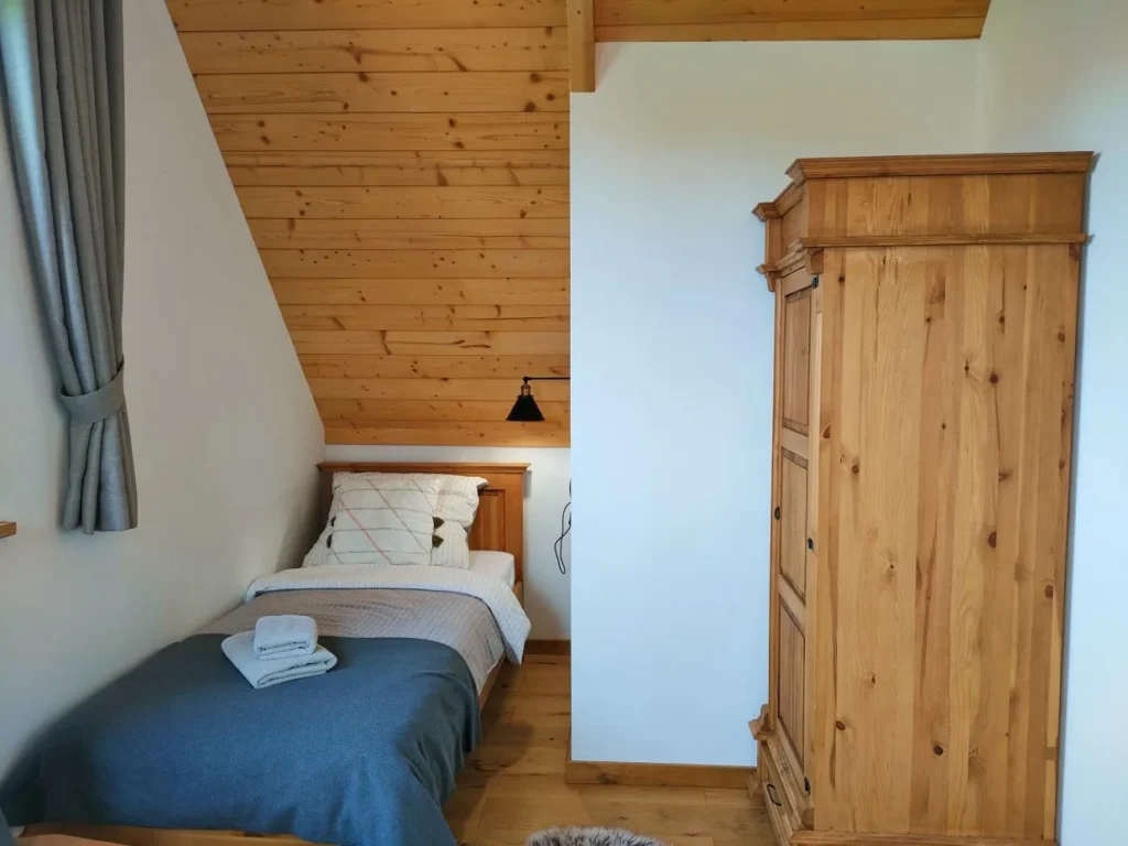 Sypialnia z pojedynczym łóżkiem i drewnianą szafą